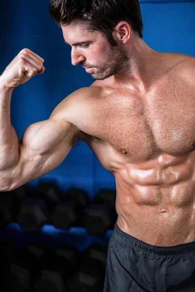 Shirtless athlete flexing muscles in gym — Stock Photo, Image
