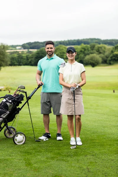 Par stående med golf club och väska — Stockfoto