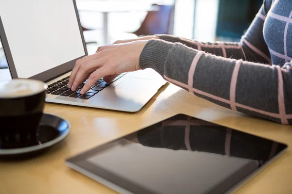 Mulher usando laptop com café e tablet — Fotografia de Stock