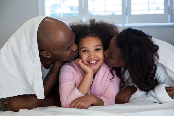 Father and mother kissing daughter — Stock Photo, Image