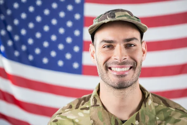 Smilende soldat mot amerikansk flagg – stockfoto