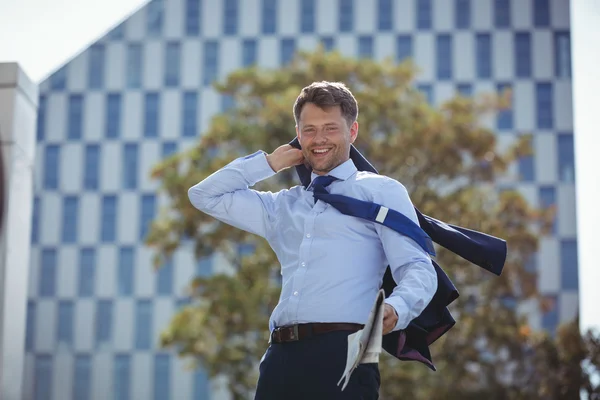 Businessman holding blazer and newspaper — Stock fotografie