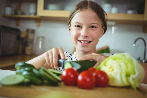 Girl cutting zucchini in kitchen at home — ストック写真