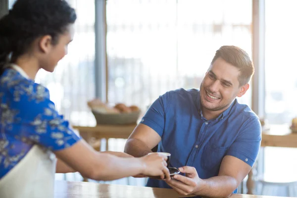 Serveuse servant une tasse de café au client — Photo