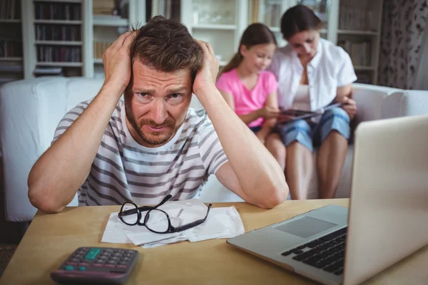 Martwi się człowiek z rachunków i laptopa — Zdjęcie stockowe