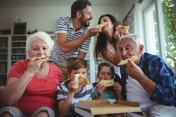 Familia multigeneracional comiendo pizza juntos —  Fotos de Stock