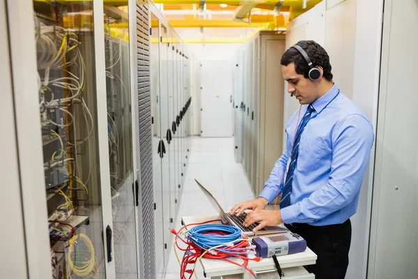 Technician in head phones using laptop — Stock Photo, Image