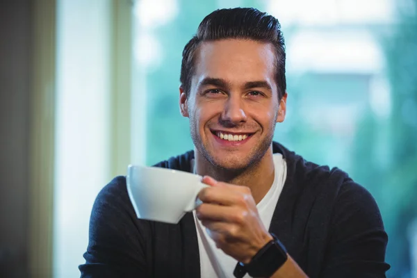 Bonito homem tomando xícara de café no café — Fotografia de Stock