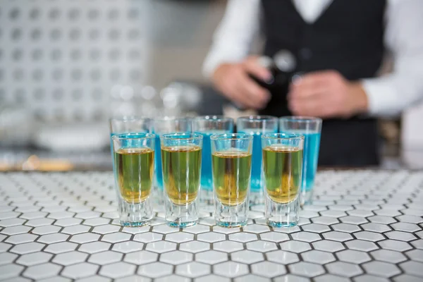 Glazen blauwe lagune drankjes en whisky — Stockfoto
