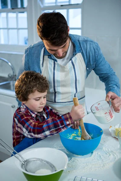 Far och son förbereder cupcake — Stockfoto