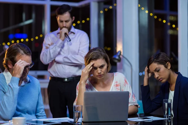Verkrampte zakenmensen die op laptop werkt — Stockfoto