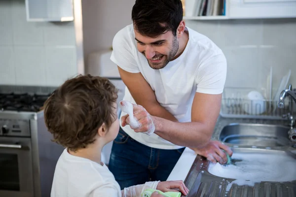 Zoon helpen vader in gebruiksvoorwerpen wassen — Stockfoto