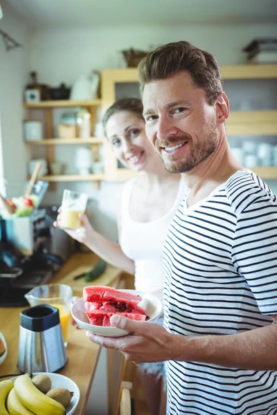 Пара держит пластину с арбузом на кухне — стоковое фото