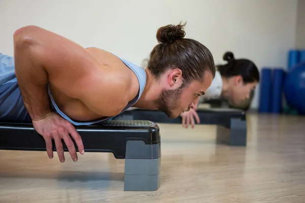 Män gör aerob träning på stepper — Stockfoto