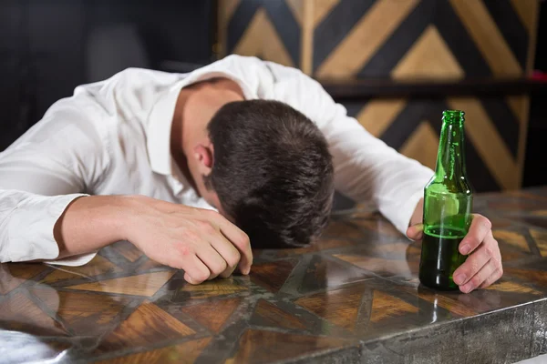 Opilý muž ležící na počítadlo — Stock fotografie