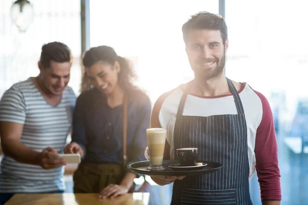 Cameriere sorridente che tiene il caffè in vassoio — Foto Stock