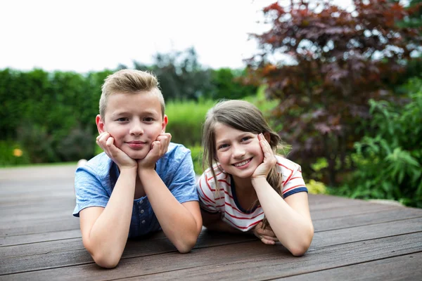 Portrait of kids lying on jetty — Stock fotografie