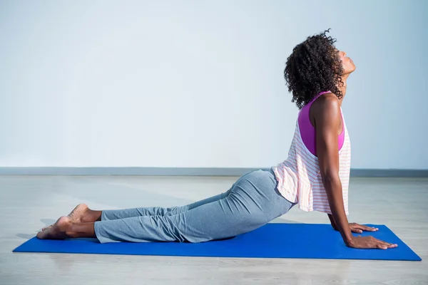 Mujer haciendo pose cobra en alfombra de ejercicio — Foto de Stock