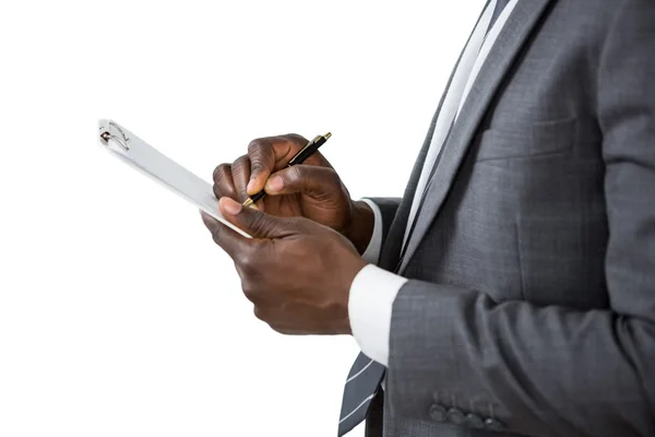 Businessman writing on clipboard — Stock Photo, Image