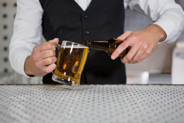 Barista versare birra su vetro — Foto Stock