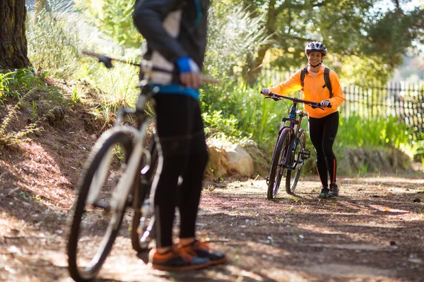 Vrouwelijke biker wandelen met mountainbike — Stockfoto