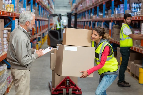 Warehouse manager noting on clipboard — Stock Photo, Image