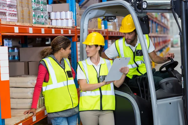 Male and female workers discussing over clipboard — Stock Photo, Image