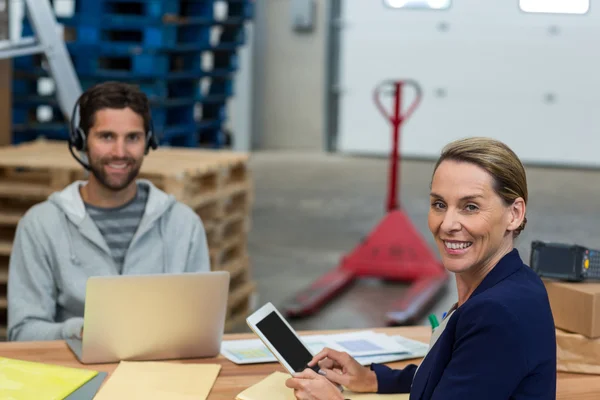 Warehouse managers using digital tablet and laptop — Stock Photo, Image