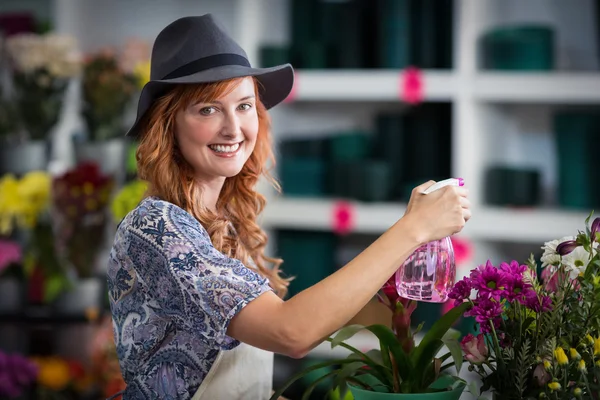 Blumenhändler sprüht Wasser auf Blumen — Stockfoto