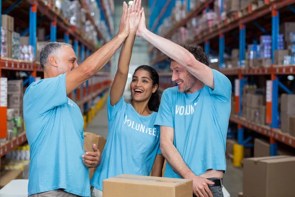 Voluntários animados dando alta cinco — Fotografia de Stock