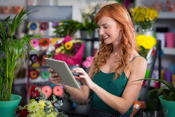 Флорист використовує планшет у квітковому магазині — стокове фото