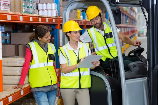 Male and female workers discussing over clipboard — Stock Photo, Image
