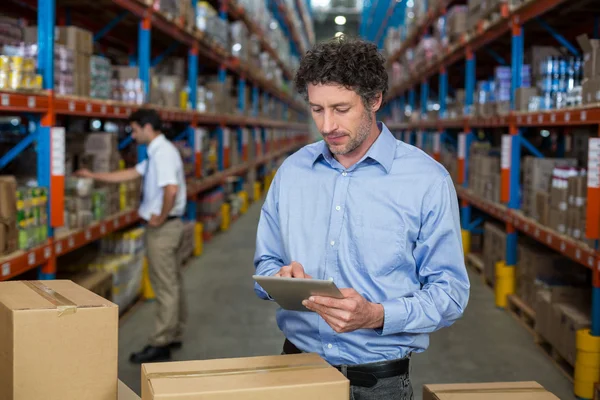 Trabajador de almacén usando tableta digital — Foto de Stock