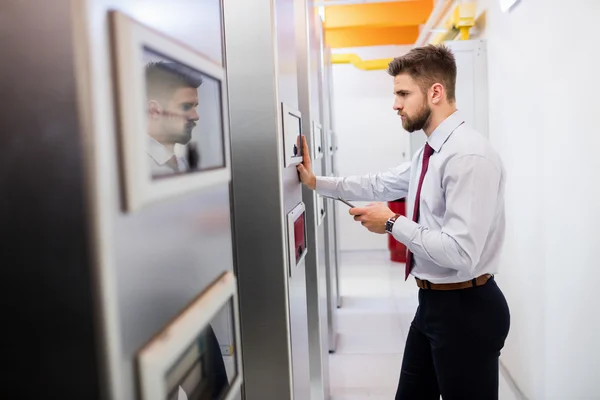 Technician looking at server cabinet — Stock fotografie