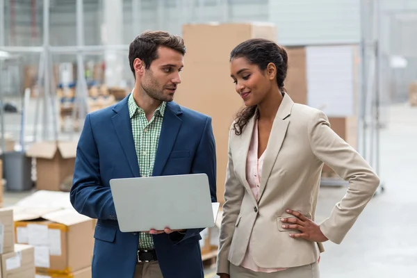 Warehouse managers discussing with laptop — Stock Photo, Image