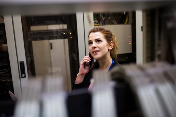 Technician talking on phone in server room — Stock Photo, Image