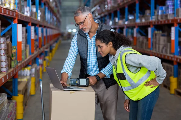 Magazijn werknemers bespreken met laptop — Stockfoto