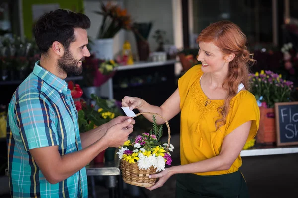 Florista dando cartão de visita ao cliente — Fotografia de Stock