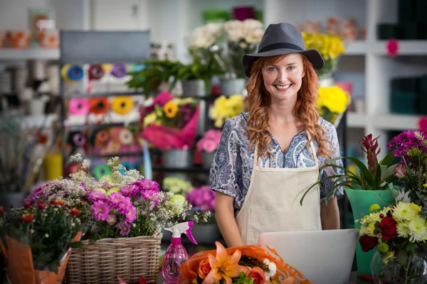 Florista usando laptop na loja de flores — Fotografia de Stock