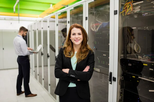 Technician standing with arms crossed in a server room — Stock fotografie