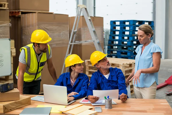 Warehouse workers discussing with manager — Stockfoto