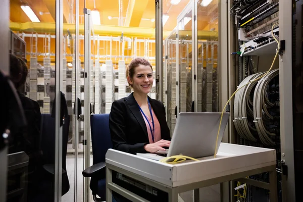 Technician using laptop while analyzing server — Stock Photo, Image