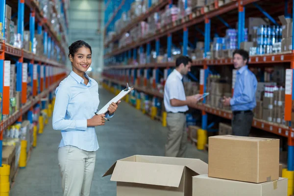 Warehouse worker standing with clipboard — Stockfoto