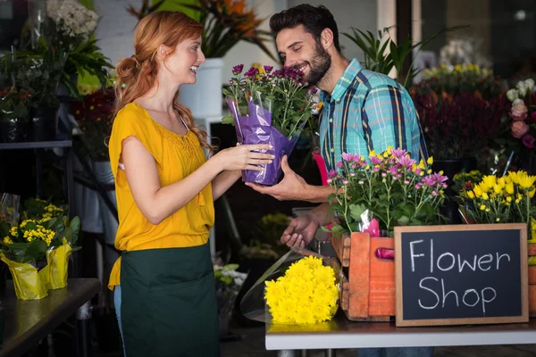 Blumenhändler übergibt Blumenstrauß an Mann — Stockfoto