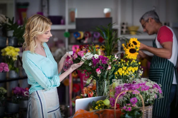 Florists spraying water on flowers — Stock Photo, Image