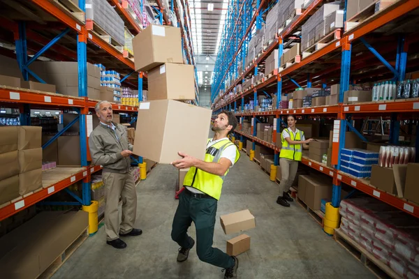 Рабочий теряет равновесие при перевозке коробок — стоковое фото