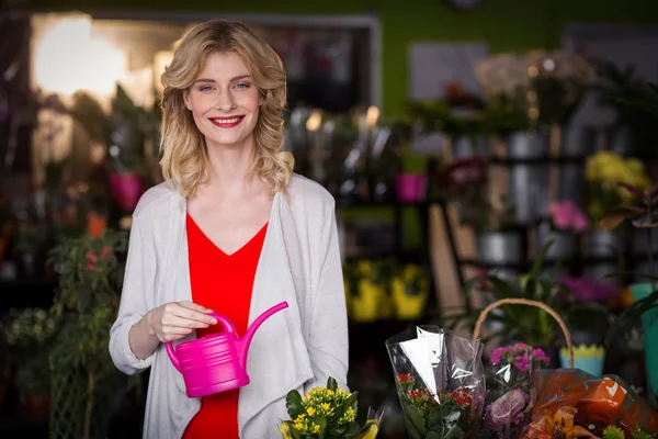 Florist holding watering can in shop — Stock fotografie