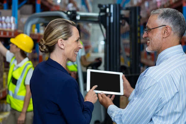 Magazijnbeheerder en cliënt bespreken over Tablet PC — Stockfoto