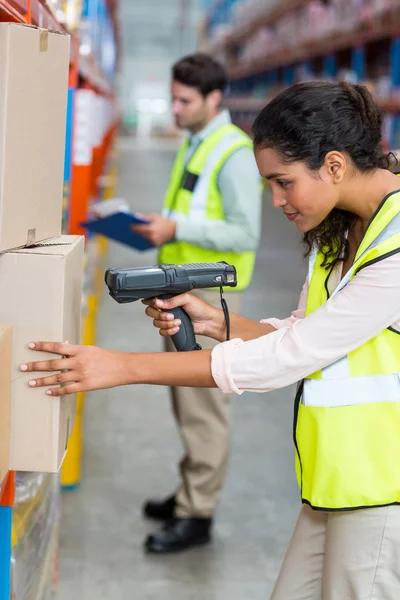 Female warehouse worker scanning box — ストック写真