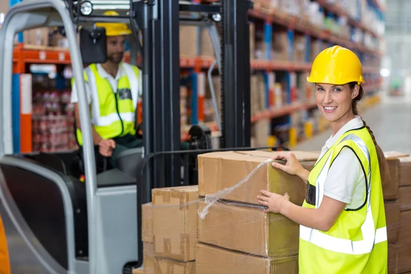 Trabajadora sonriendo en el almacén — Foto de Stock